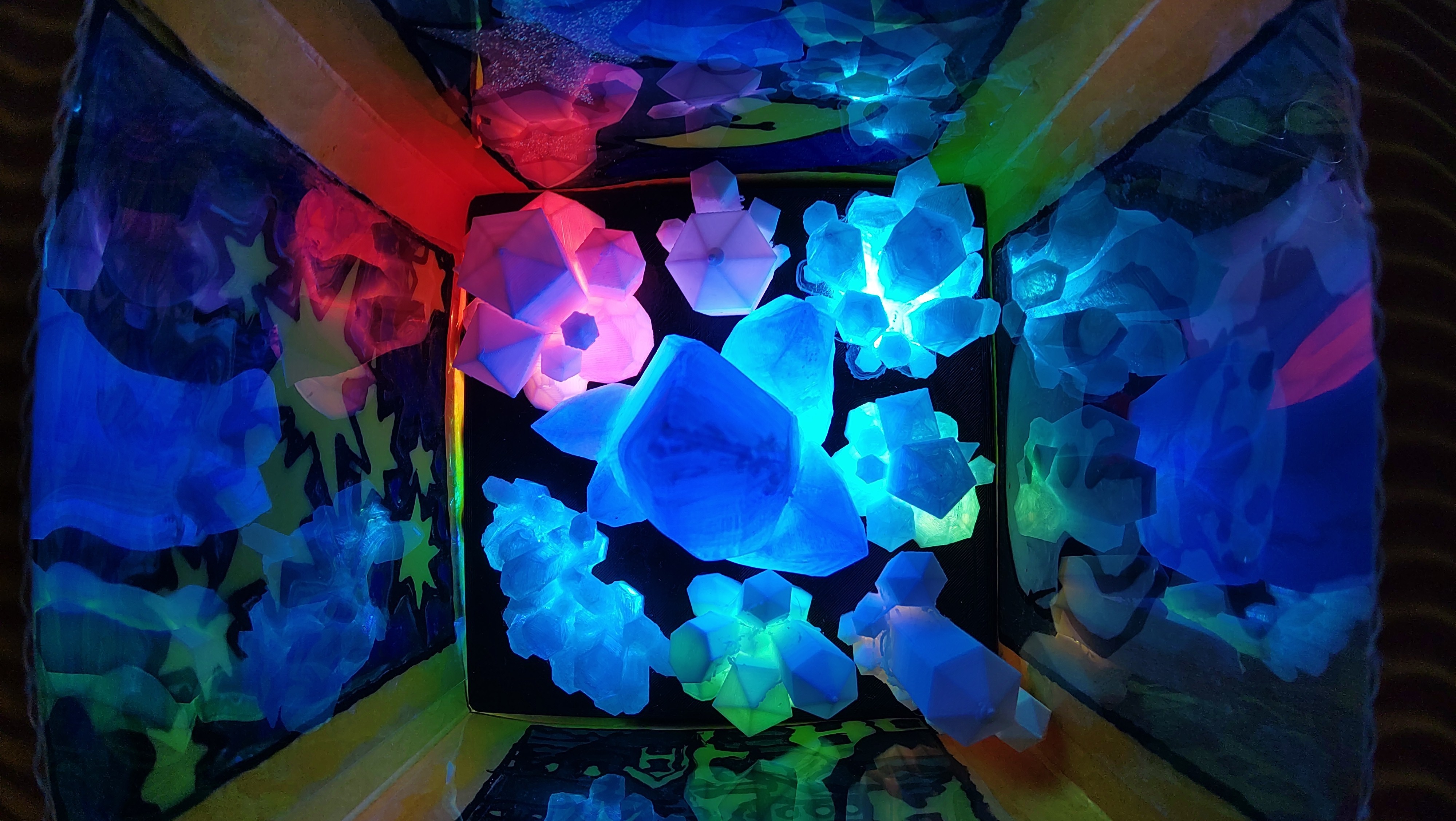 Blick von oben in eine aus Pappe gebastelte Laterne in der sich mittels LED illuminierte Kristalle befinden